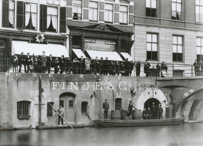 879230 Afbeelding van een schip met wijnvaten van wijnhandel Finjé & Co bij een opslagkelder van de firma onder het ...